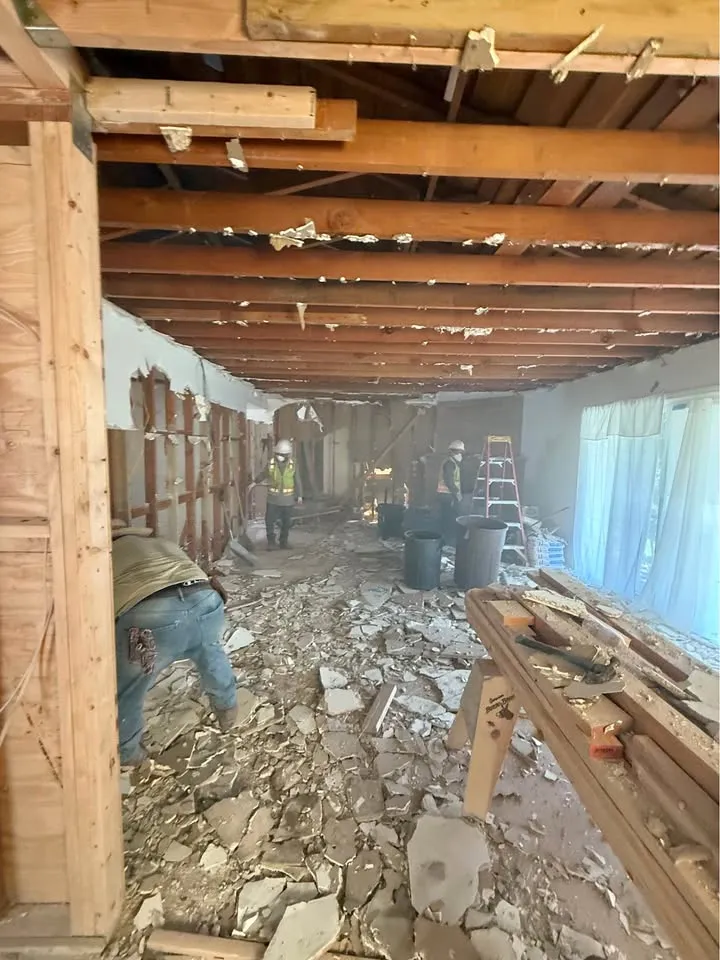 Crew member clearing debris under an opened ceiling