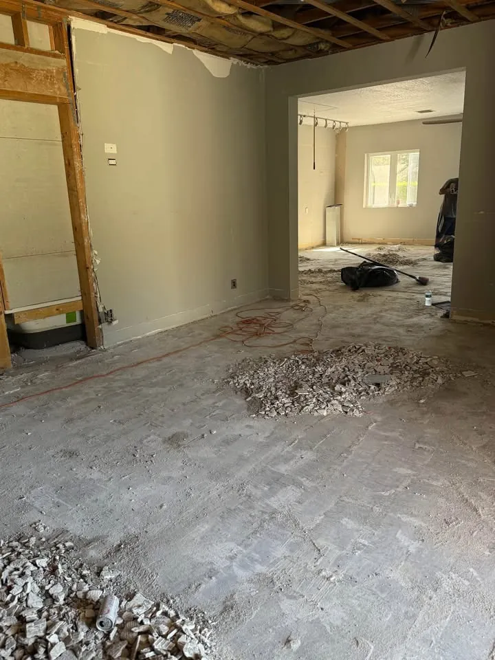 Room with the ceiling opened and debris piled on the stripped floor