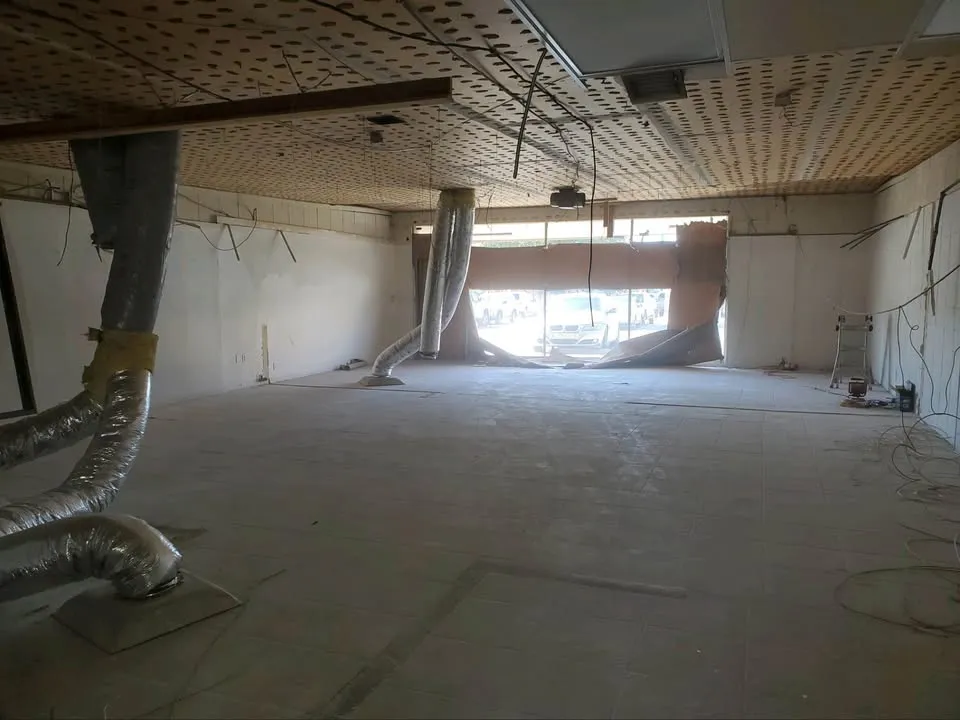 Empty commercial unit with ceiling opened and ductwork exposed, the end state a scope of work describes