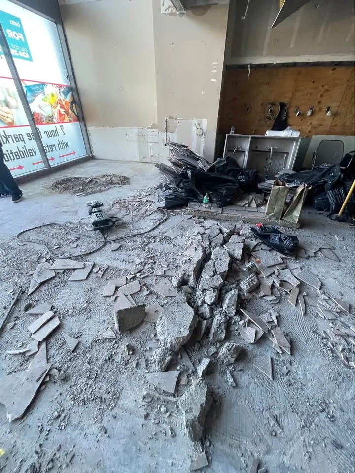 Storefront interior with floor tile broken up beside the front windows