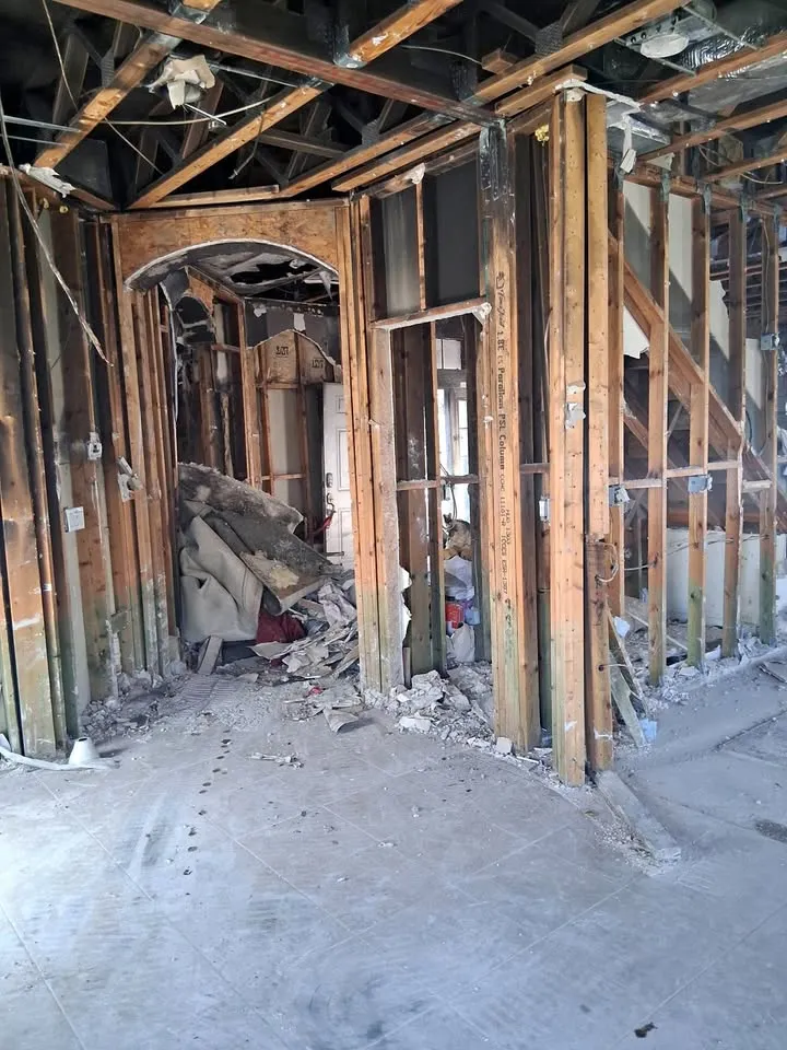 Fire-damaged interior stripped to studs and ceiling joists