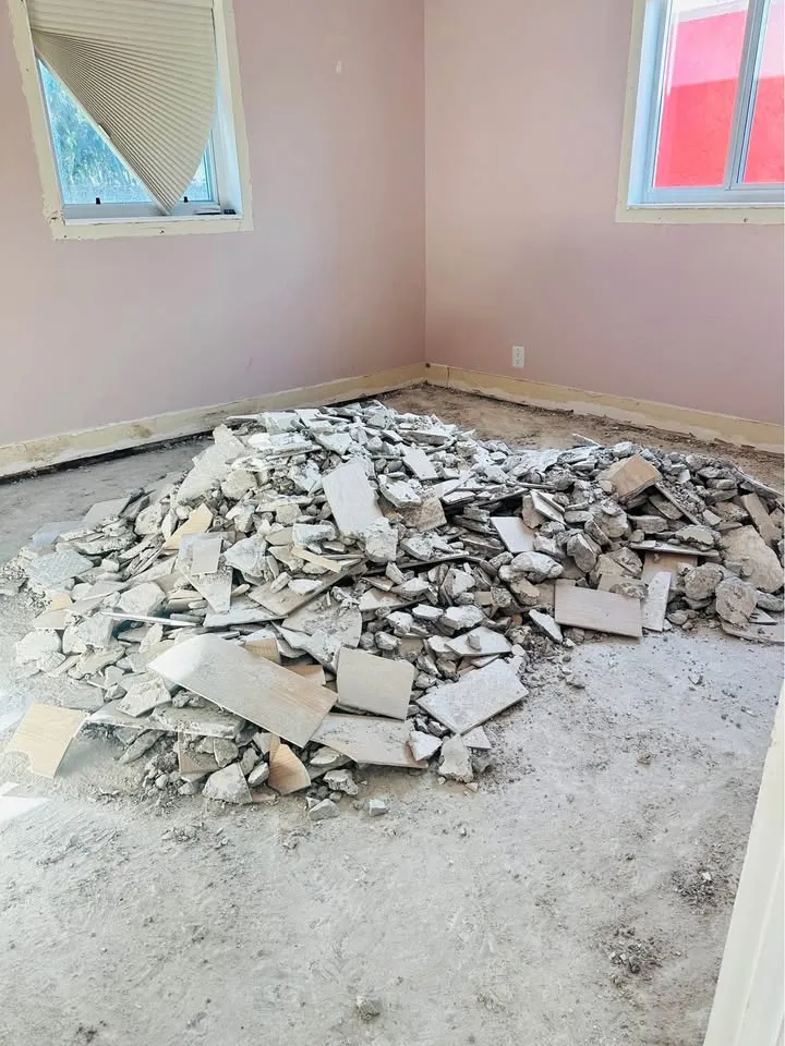 Bedroom with a pile of broken tile and drywall on the floor