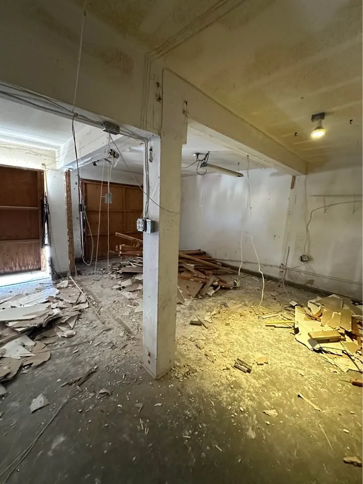 Basement with walls opened and wood debris on the floor