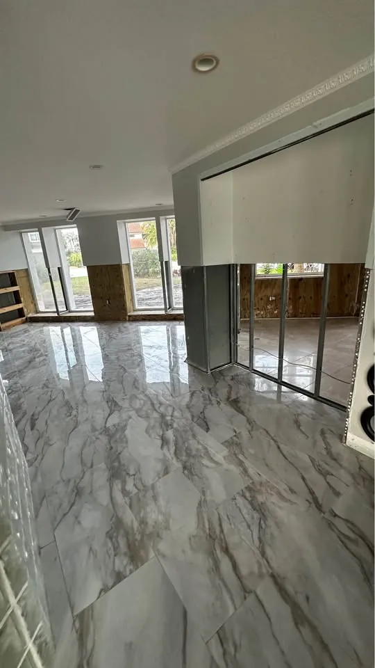 Room with glossy large-format floor tile and open walls beyond