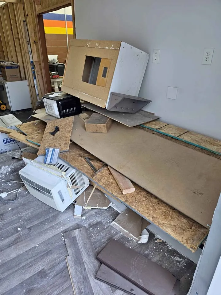 Room with boards and old appliances piled for removal