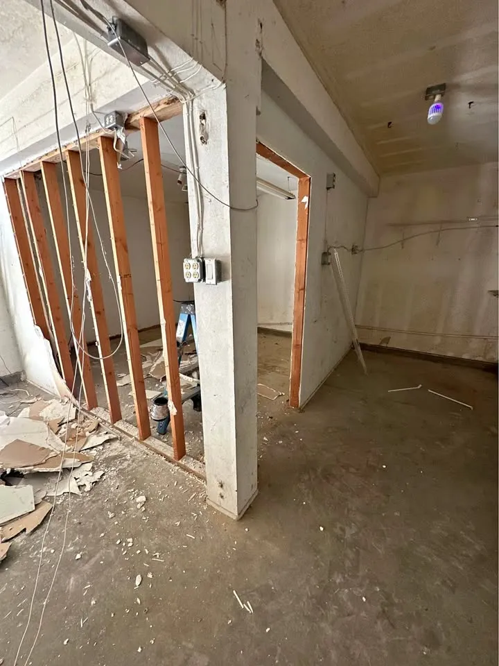 Room with a partition wall opened to studs