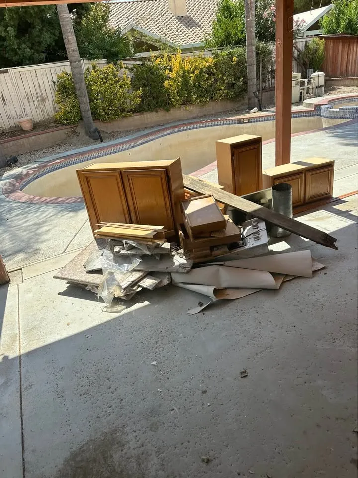 Removed cabinets stacked outside on a pool deck
