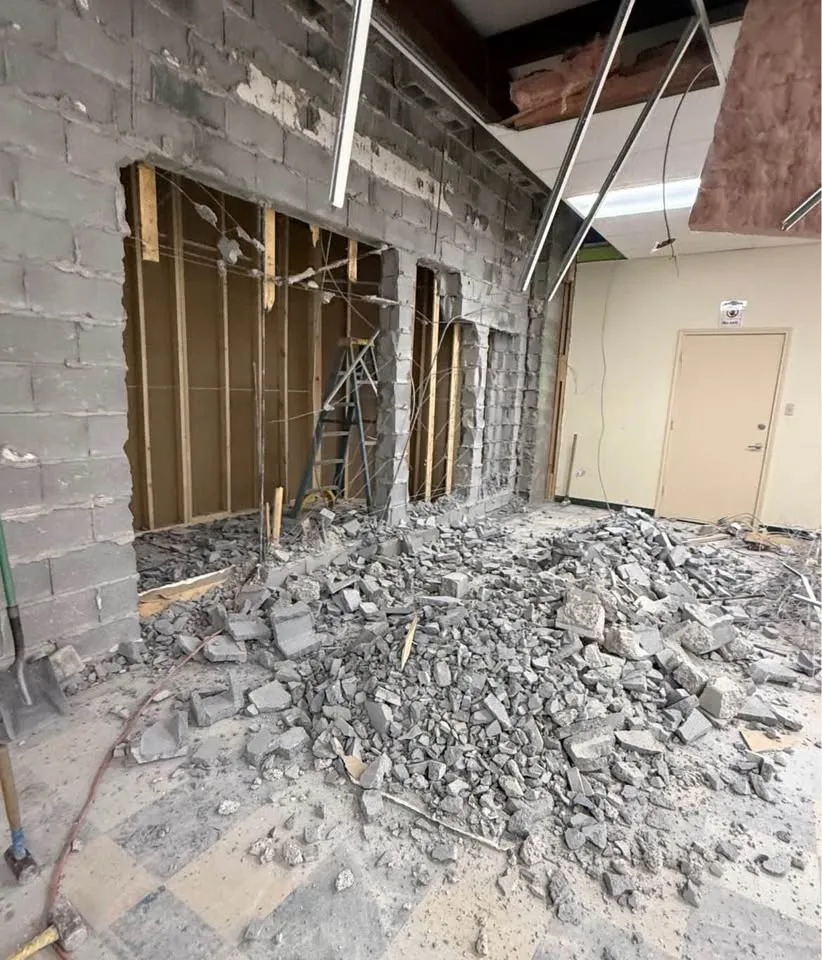 Block wall broken down inside a commercial unit with rubble on the floor