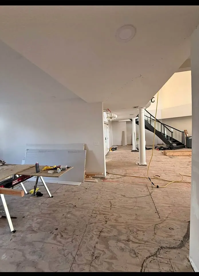 Open living area with flooring scraped to the slab near the staircase