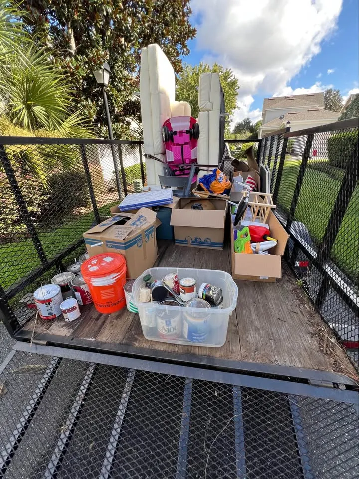 Trailer loaded with boxes, paint cans and furniture being hauled away
