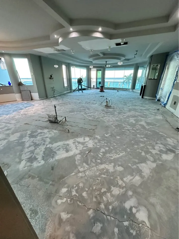 Large open room with floor finishes scraped down to the subfloor