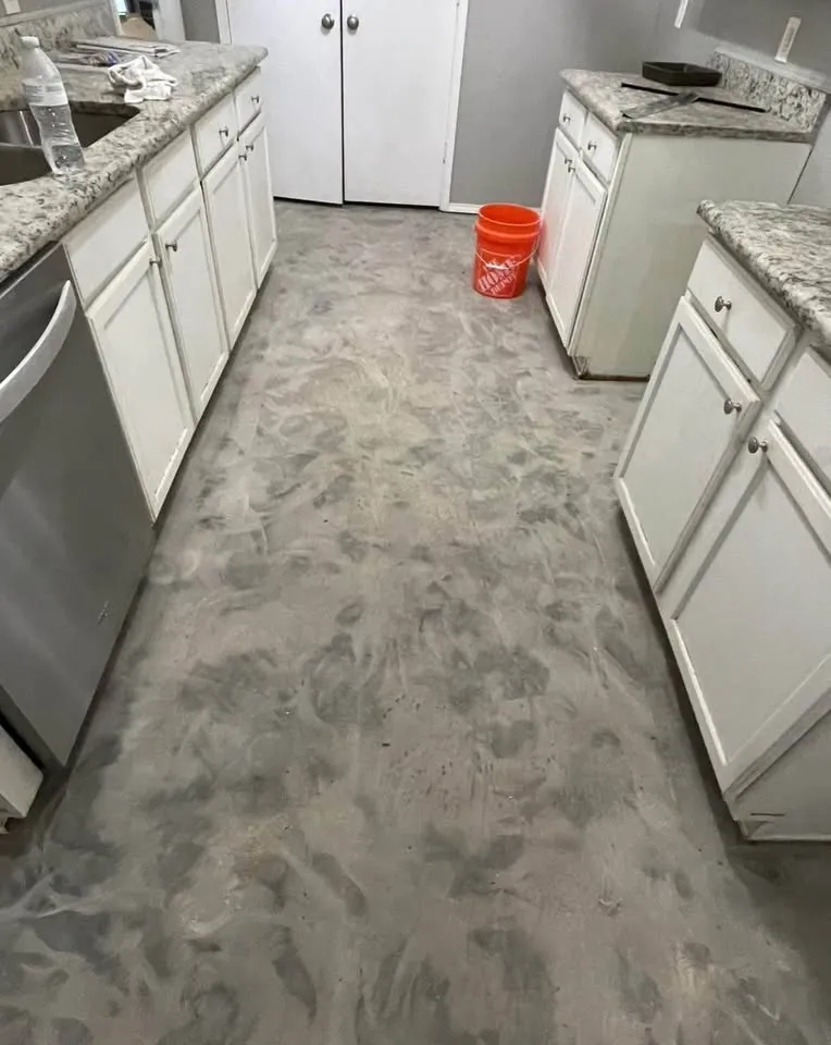 Galley kitchen with flooring removed between the cabinets
