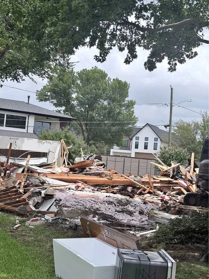 Debris pile where an older house was taken down, with neighbouring homes behind